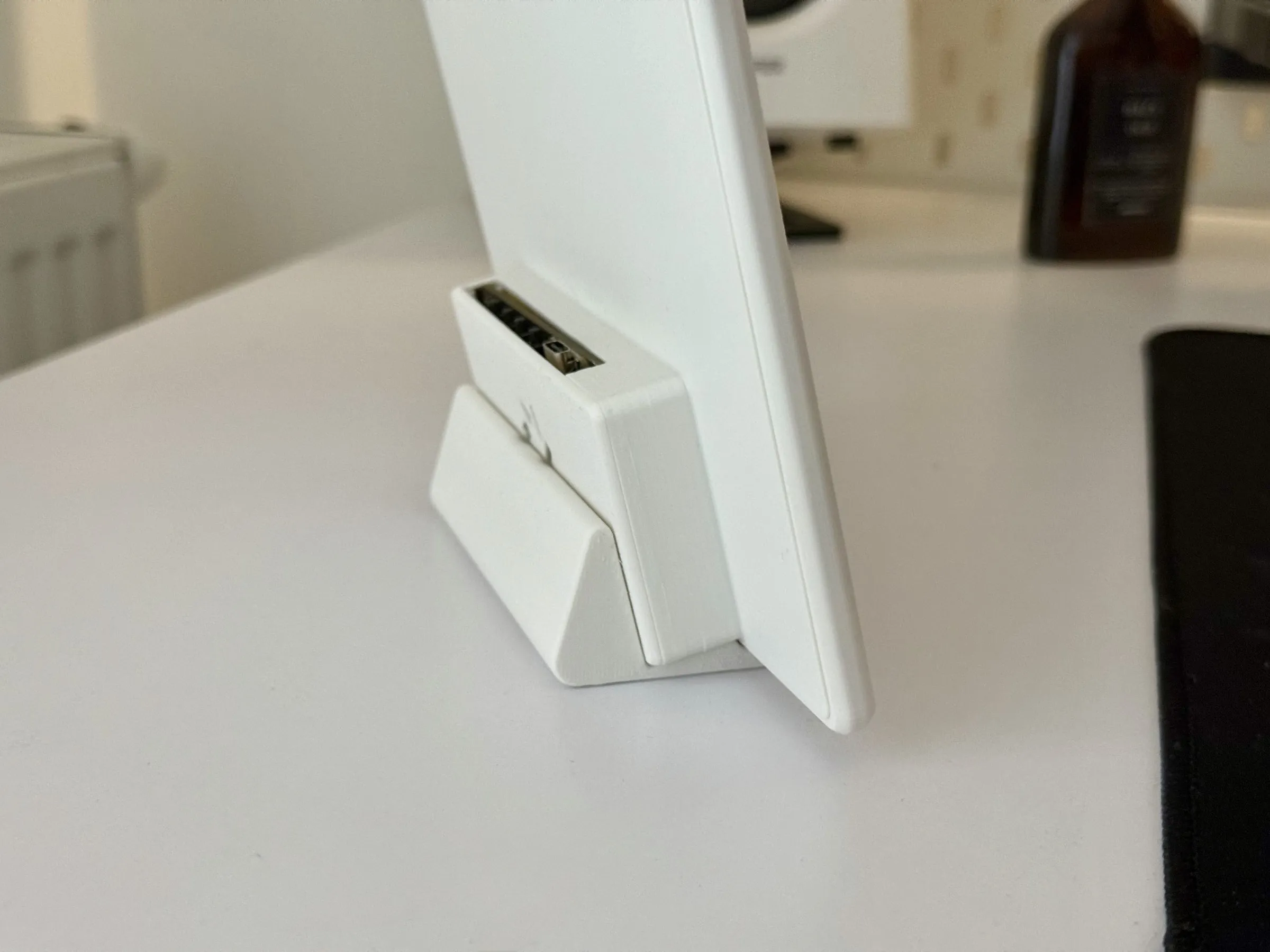 The case from the side, sitting in a white wedge-shaped desk holder